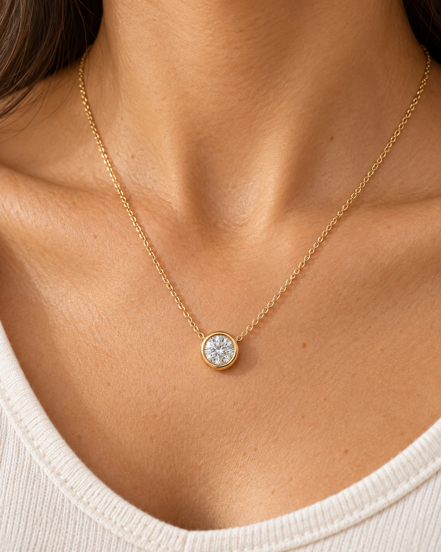 AI-generated visualization — yellow-gold Bezel Solitaire Pendant worn at the collarbone.
