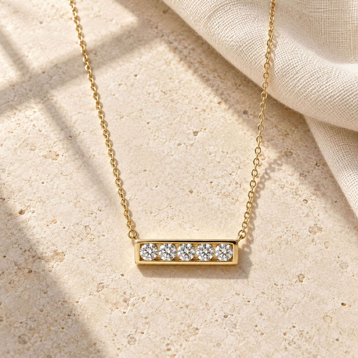 AI-generated visualization — yellow-gold Five-Stone Bar Necklace on limestone beside linen in window light.