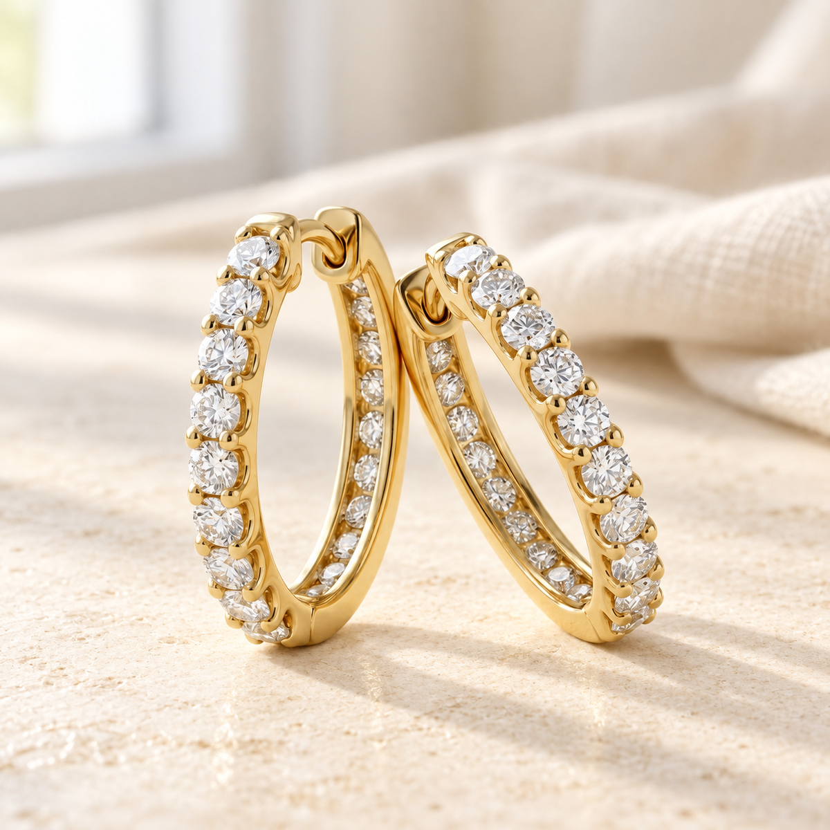 AI-generated visualization — Inside-Out Huggie Hoops in yellow gold on a pale tabletop in natural window light.