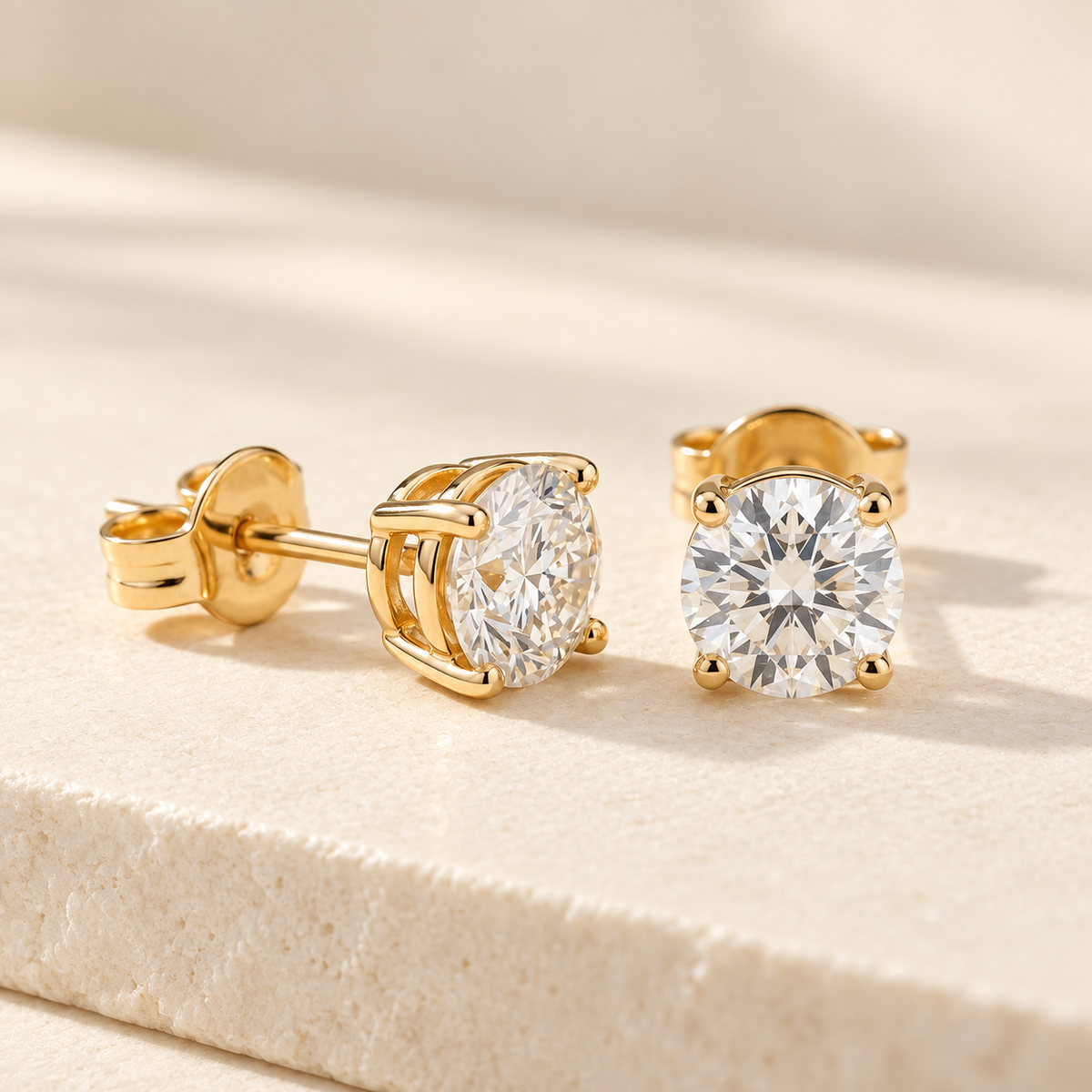 AI-generated visualization — yellow-gold four-prong Lab Diamond Stud Earrings on an ivory studio display.